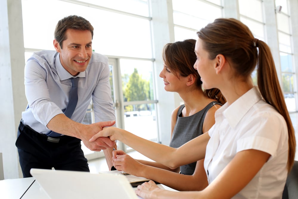 Salesman shaking hands to clients Salesman shaking hands to clients